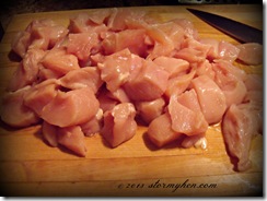 raw chicken cubes on board