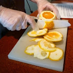 To properly slice an orange, you cut the skin and pith from the top and bottom first. Then from the sides, allowing your knife to follow the curve of the orange.