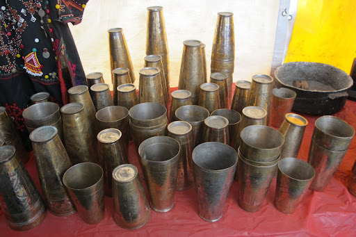 A grouping of brass vessels intricately carved with beautiful designs.