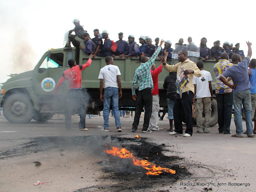  – Un véhicule de Fardc passe avec des éléments de la PNC devant des partisans de l’UDPS  le 26/11/2011 le long du boulevard Lumumba à Kinshasa, lors de l’arrivé d’Etienne Tshisekedi en provenance du Bas-Congo. Radio okapi/ Ph. John Bompengo