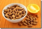 2388028-bowl-of-fresh-almonds-and-an-orange-on-a-rattan-mat-of-warm-color