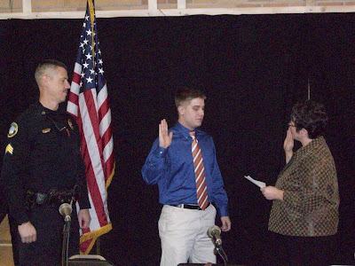 Mayor Sandra Johnson swearing in Brett Johnson as police officer at the November 16, 2011 City Council meeting.  Looking on is Officer Shawn Ellingson.
