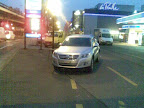 Il y a trois endroits pour se parquer sur cette photo : le centre commercial, la station service et le parking cyclable. C'est ben pratique. (rte des jeunes, 18.1.2011)