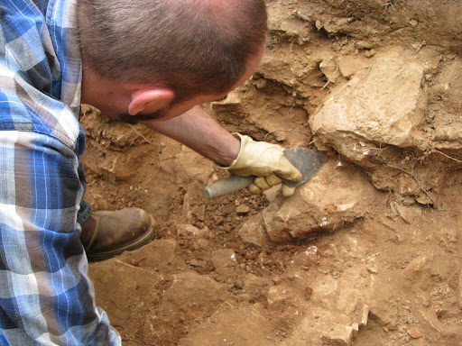 Dr. Dobson demonstrating the process of carefully digging in an archaeological site.
(Photo credit: Jeremy Shreckhise)