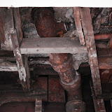 The waste pipe where it connects to the toilet, with the cement that encased it already removed, viewed from the living room below