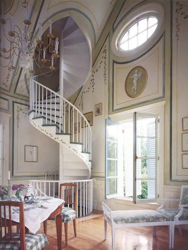 Such beauty in the circular staircase, painted walls, and simple furnishings.