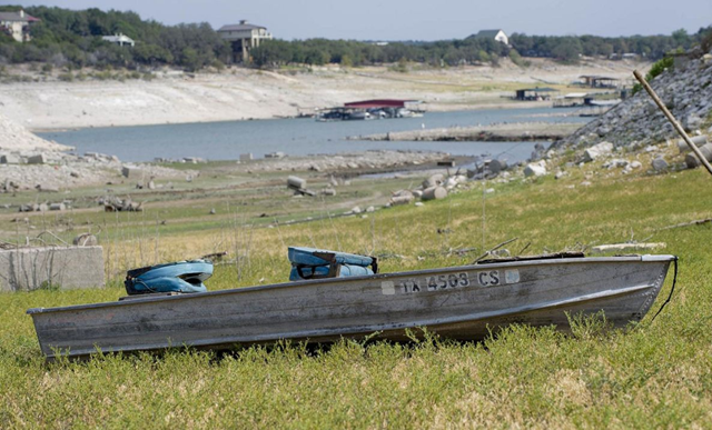 A boat rests on the dry bed of Hurst Creek of Lake Travis, Texas. The creek ran dry during the summer drought of 2011.  TPWD via blog.chron.com