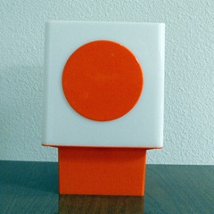 white lamp with orange base and orange dot