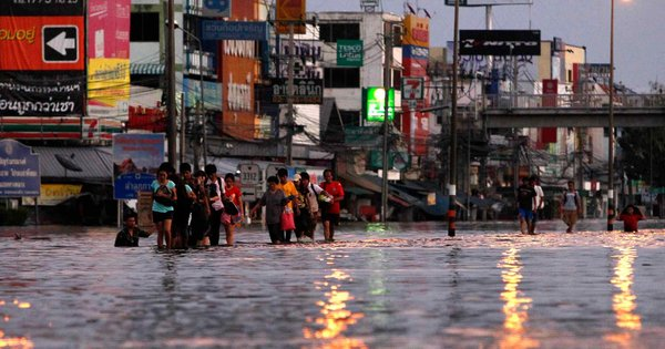 Thais wade through a flooded street in Bangkok on Thursday, 27 October 2011. Sukree Sukplang / Reuters