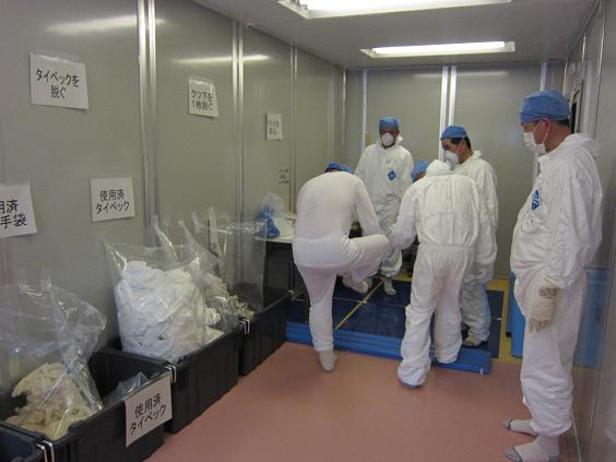 Workers at the Fukushima Daiichi nuclear plant remove contaminated clothing before entering the Hitachi/GE rest area, June 2011. TEPCO