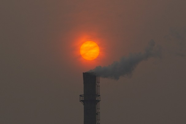 Smoke billows from a chimney of a heating plant as the sun sets in Beijing in this file photo dated Monday, 13 February 2012. U.N. climate talks being held in Bonn, Germany, are in gridlock on Thursday, 24 May 2012, as a rift between rich and poor countries risks undoing some of the advances made last year in the two-decade-long effort to control carbon emissions from fast-growing economies like China. Alexander F. Yuan / Associated Press