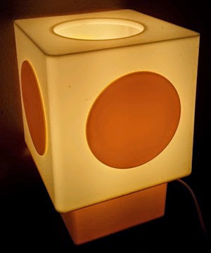 white lamp with yellow circle and yellow base in dark
