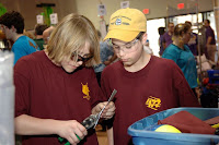 Two students cutting gear caps