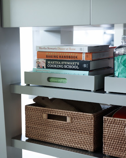 Bins and baskets are a great way to organize cookbooks and other items on exposed shelves.