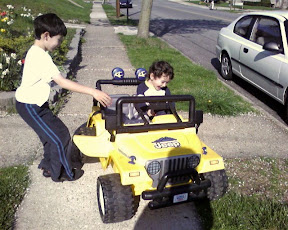 Kai and Eidan riding on the neigbor's battery powered mini Jeep