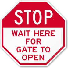 c0 This sign says Stop, Wait Here for Gate to Open