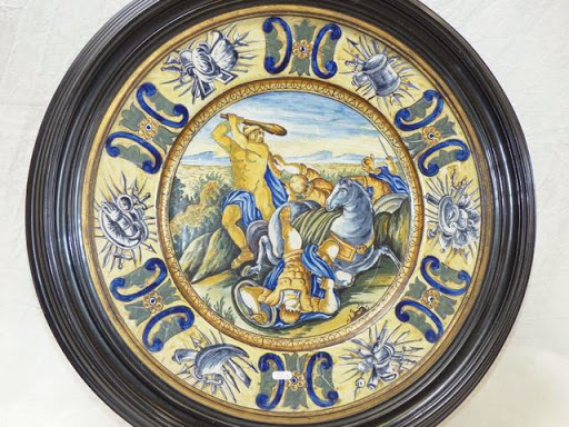 Vente du samedi 28 mars 2015 par la maison Darmancier & Clair à Bourges : NEVERS paire de plats en faïence à décor polychrome figurant des scènes de l'Antiquité. Aile à décor trophées de guerre. Diam: 41.5 cm. Cadre en composition rapporté. Estimation : 3 000 - 4 000 euros