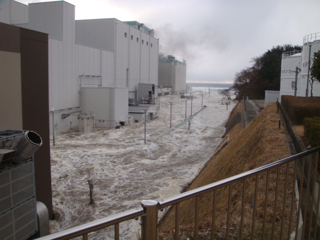 Tsunami wave floods an access road next to the Fukushima Daiichi nuclear power plant, 11 March 2011. TEPCO / japannewstoday.com