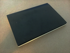 Closed notebook, with plain black cover and black enpapers just visible.