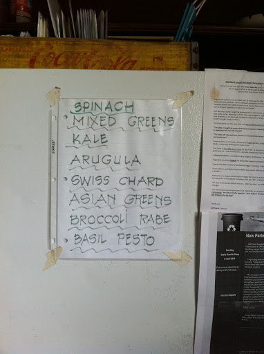 Handwritten sign on the barn fridge advertises the day's greens. Handwritten sign on the barn fridge advertises the day's greens.