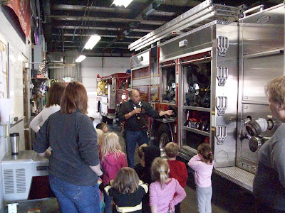 Firefighter Joe Redlinger shows equipment to children from the First Baptist Preschool.