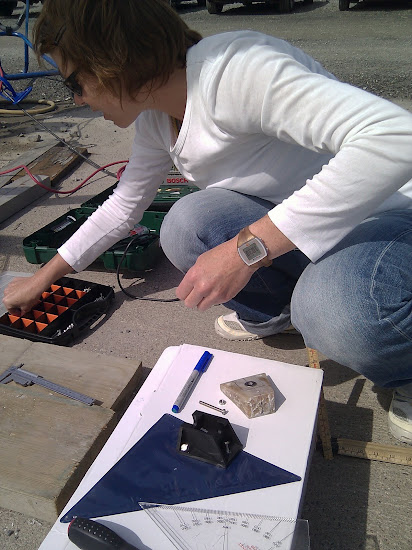 Julie kollar hur man fäster plastblocket (gult) som korrigerar masttoppens lutning på ca 15 grader och fästet (svart) till vindmätaren.