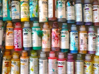 Organized paint bottles show the many colors of Booth's work.