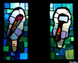 To the left it is a fuller's club that is said to have been the tool with which James (the Younger), son of Alphaeus, was beaten to death in Egypt. However, Josephus claims he was stoned in Jerusalem.
To the right it is Judas Thaddeus symbolized with an axe. StainedWindows-1021.jpg