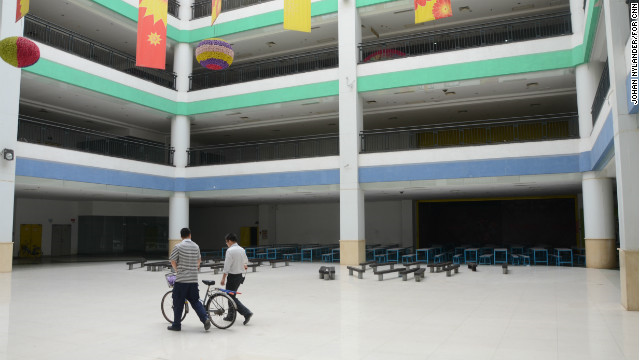 Two men walking through the empty South China Mall mall in a space planned for restaurants. Photo: CNN