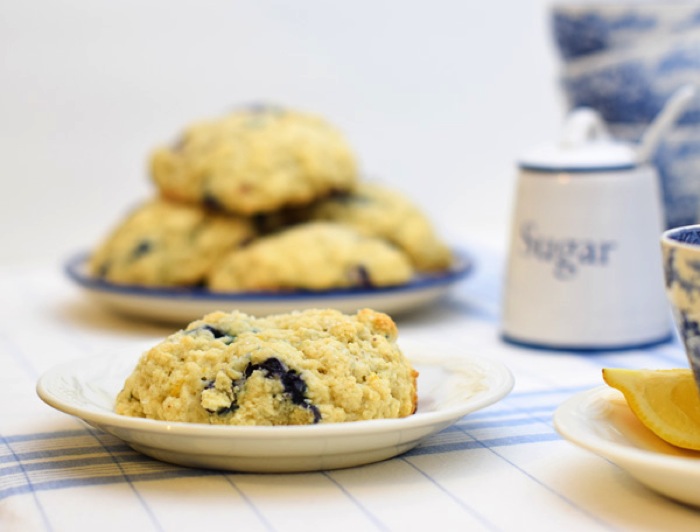 Knock Off Starbucks Scones for a Downton Abbey Tea Party. A melt in your mouth recipe for blueberry scones. Inspired by Starbucks in house version, this blueberry scone with hints of lemon and a crunchy sugary top will delight everyone. Serve during High Tea, or just as a mid afternoon snack. Perfect along side tea or coffee, or as a stand alone blueberry dessert. You won't believe how easy these are to make! Never made scones before? Never fear, this includes a step by step tutorial on how to make scones. #HighTea #blueberries #Starbucks #scones #dessert Knock Off Starbucks Scones for a Downton Abbey Tea Party