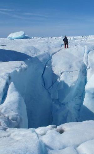 Marco Tedesco standing on the edge of one of four moulins (drainage holes) he and his team found at the bottom of a supraglacial lake during the expedition to Greenland in the summer of 2011. P. Alexander