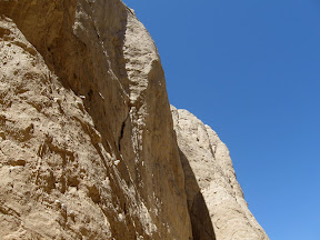 Sand colored cliffs contrast against a brilliant blue Desert sky.