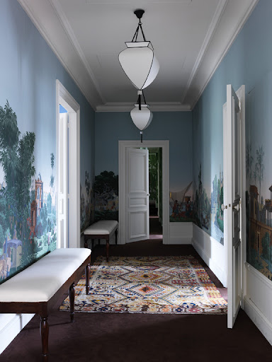 This cool-toned, exotic wallpaper by Zuber and a contrasting bold rug instantly transport and mesmerize all who enter; white trimmings keep the colorful accents polished and clean. This cool-toned, exotic wallpaper by Zuber and a contrasting bold rug instantly transport and mesmerize all who enter; white trimmings keep the colorful accents polished and clean.