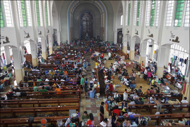 After Tyhoon Haiyan struck the Philippines, people took refuge in a Catholic church converted to a disaster relief centre in Tacloban City, 10 November 2013. The Philippines faced a humanitarian crisis days after the typhoon hit much of the Visayas with 1.9 million homeless and more than 6,000,000 displaced. In Tacloban alone, ninety percent of the structures are either destroyed or damaged. Photo: IBT