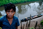 A treacherous walk down a slippery river bank in the morning to bathe.  Here a boy returns from a fishing trip.