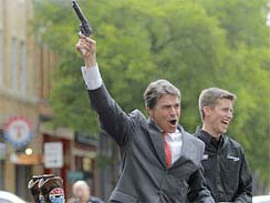 Texas Governor Rick Perry fires a pistol in the air. wonkette.com