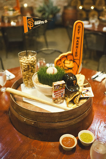 The centerpieces, which were designed by Kathy Goodman of Well Rehearsed, included standard stadium fare: peanuts, Cracker Jacks, baseball mitts, grass, and a ball. The centerpieces, which were designed by Kathy Goodman of Well Rehearsed, included standard stadium fare: peanuts, Cracker Jacks, baseball mitts, grass, and a ball.