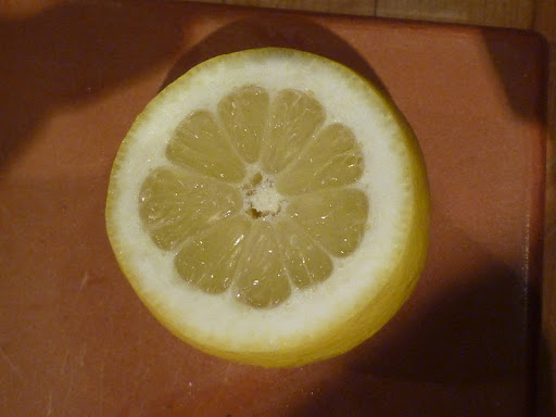 Lemon trimmed to reveal fruit under the skin.