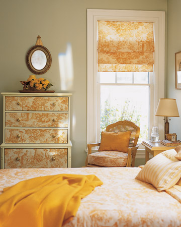 Drawer fronts covered in a sunny yellow toile fabric look distinctive. For a project like this one, choose wooden drawers with easy-to-remove faces, such as those held together with nails or screws.