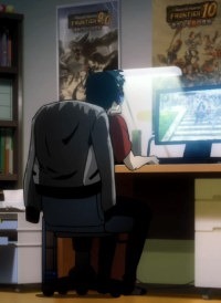 Kon sits at his computer with back to the viewer, headphones on, coat slung over his desk chair, and various gaming posts coating the walls