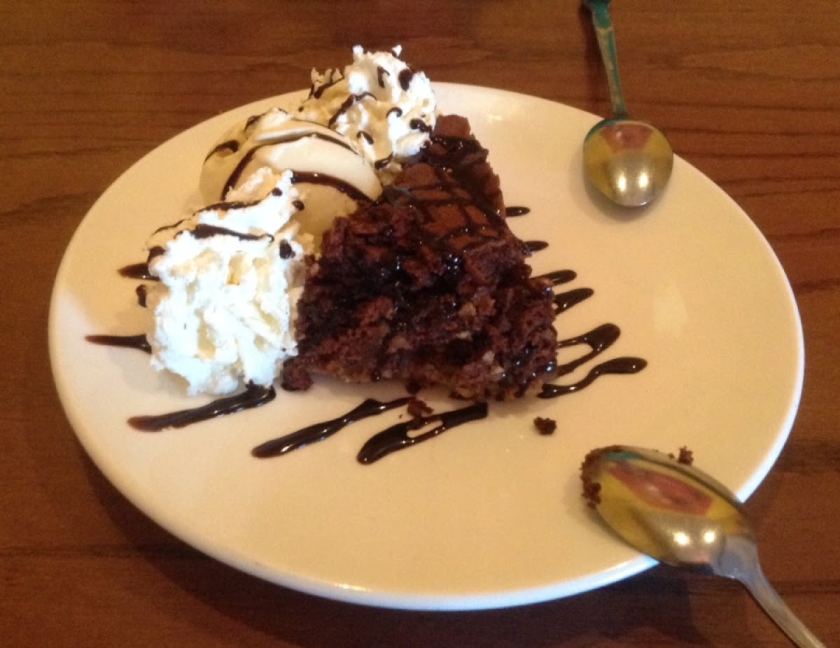 Delicious flourless cake with hazelnuts served with ice cream and whipped cream.