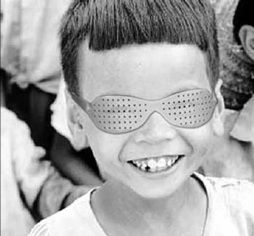 Niño con gafas estenopeicas