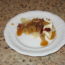 Butternut Squash ravioli with caramelized onions, browned pecans, soaked cranberries, and apple cider reduction