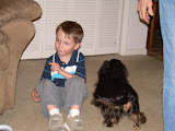 Jay sitting on the floor as Winkie walks past him.