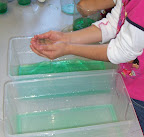 child scooping green-colored water