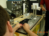 Chris experiments with a laser-alignment process as an engineer from NCR watches.