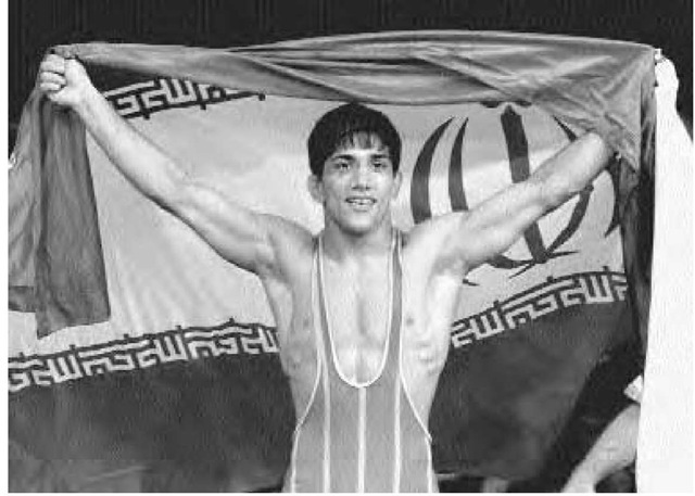 Alireza Dabir of Iran waves his country's flag after winning the gold medal for freestyle wrestling at the Sydney Olympics, October 1, 2000. 