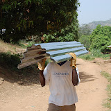  &ndash; Truck arrives in Kabala and is unloaded at Pa Foday's house. They carry it to the school site. Pa Foday is under these zinc sheets …. © 2008 NHA Photos