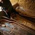 An Egyptian worker brushes dust off a wooden coffin containing a linen-wrapped mummy covered in cartonnage near the Illahun Pyramid in Faiyum, 130 km (80 miles) southwest of Cairo , April 26, 2009, released by the Egyptian Supreme Council of Antiquities. REUTERS/Tarek Mostafa