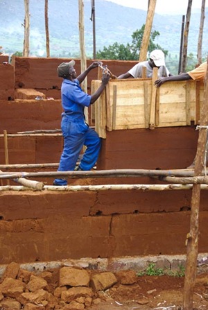 Master Mason Paul setting the form on the wall between the windows of bedrooms 2 and 3